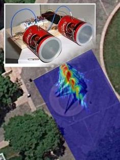 an aerial view of two red cans on top of a blue area with trees in the background