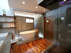 a bathroom with a tub and wooden floors