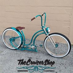 a blue bicycle is parked in front of a building with the words the cruiser shop on it