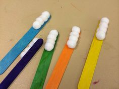 four toothbrushes are lined up in different colors on a table with one painted white and the other blue