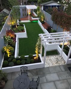 an aerial view of a small backyard garden with lawn and seating area at night time