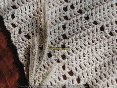 the crocheted blanket is laying on top of the wooden floor