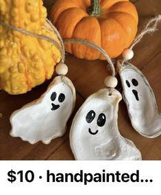 two white ghost ornaments on a table with pumpkins in the background and text overlay that reads $ 10 handpainted