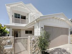 a large white house with two garages on the front and one story above it