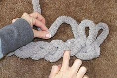 someone is crocheting a knot on the floor with their fingers and thumbnails