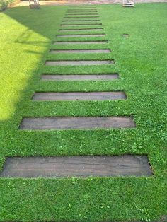 a set of stepping stones in the middle of a grassy lawn with grass growing on it