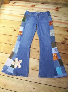 a pair of jeans with patchwork and flower appliqued on the side