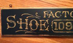 a sign that says factory shoes on the side of a wooden table next to a pair of scissors