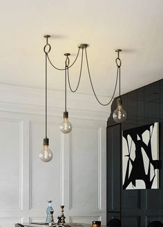 a dining room table with four lights hanging from it's ceiling and two chairs in front of the table