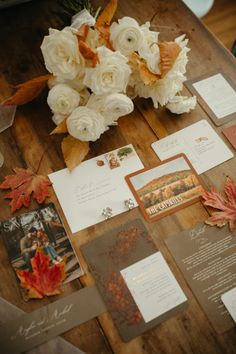 wedding stationery with flowers and cards on a wooden table in front of the camera