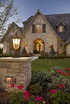 a large house with lots of windows and flowers in front of the entrance to it