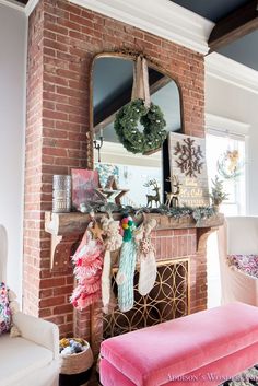 a living room decorated for christmas with wreaths on the mantel and pink bench