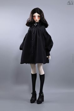 a doll dressed in black is posed for the camera with her hands on her hips