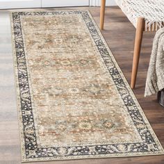 a large rug with an ornate border on the floor in front of a wooden table