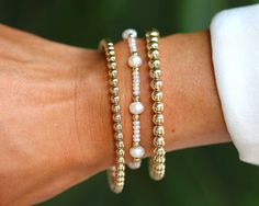 Waterproof | Tarnish Free | Hypoallergenic Bracelets: 4mm Classic($46), Claire($65), 5mm Classic($72) Bead Material: Gold filled, freshwater pearls STRETCHY LENGTH: 6.5" OR 7" CLASP LENGTH: 6" + 1.5" EXTENSION High Performance Elastic Made in miami, made with love Fancy and fresh! All our ball bead bracelets are made to be worn in the pool, shower, ocean, or wherever your bohemian adventures take you. Bracelets Stack, Jewelry Wishlist, Pool Shower, Bead Bracelets, Beaded Material, Hand Jewelry, Bracelet Collection, Bracelet Stack, Business Ideas