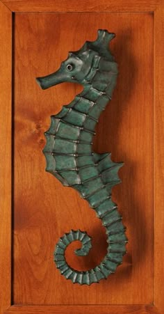 a sea horse is mounted on a wooden door with an intricately carved frame in the shape of a rectangle