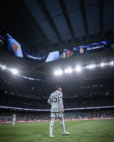 a soccer player stands on the field in front of an empty stadium during a match