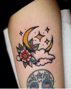 a woman's thigh with a skull and crescent moon tattoo on her left leg