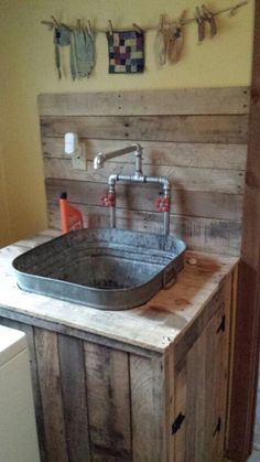 a sink made out of pallet wood with a faucet in the middle