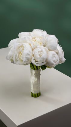 a bouquet of white flowers sitting on top of a table