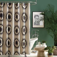 a bathroom with green walls and a shower curtain in the center is decorated with black and white sunbursts