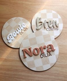 three round stickers with the words brown, green, and nora dila on them