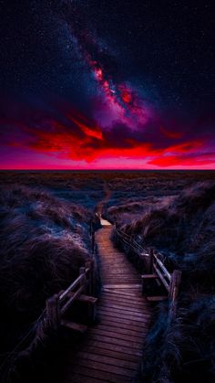 a wooden walkway leading to the stars in the sky