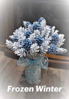 a vase filled with blue and white snowflakes on top of a wooden table