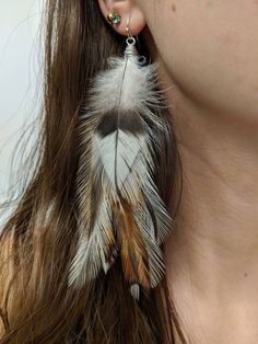 These natural feather earrings are approximately 5.5 inches long. They attach to a sterling silver ear wire and come with a rubber backing. The feathers are secured with jewellery glue and wrapped with tarnish resistant silver coloured wire to ensure longevity.  *All feathers are ethically sourced from small farms and are cruelty free. White Feather Dangle Earrings, Elegant Dangle Feather Earrings, Real Feather Earrings, Character Customization, Crow Feather Earrings, Small Farms, Feather Earrings Silver, Small Farm, Feather Earrings