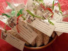 a bowl full of cookies with tags attached to them on a red cloth covered table