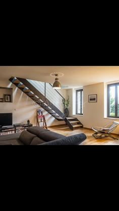 a living room filled with furniture and a stair case