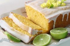 a piece of cake with frosting and limes on a plate next to it