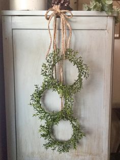 an old cabinet with some wreaths hanging on it