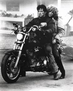 a man riding on the back of a motorcycle next to a woman