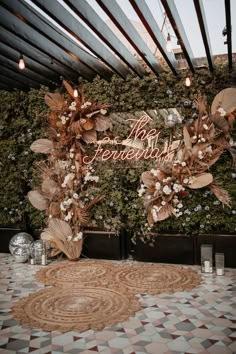 the entrance to an event decorated with flowers and leaves