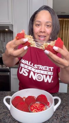 a woman is eating strawberries from a bowl