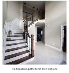 a staircase leading to the second floor in a house with white walls and wood railings