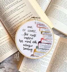 a cross - stitch bookmark with an embroidered quote on it next to two open books