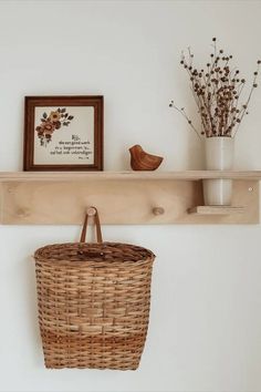 a wicker basket hanging on a wall next to a wooden shelf