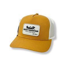 the rocky mountain trucker hat in mustard and white is shown on a white background