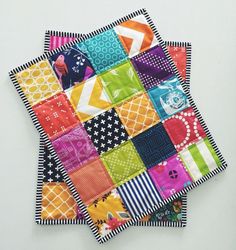 two pieces of colorful quilted material on top of each other, one with different designs