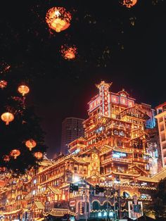 an illuminated building in the middle of a city at night