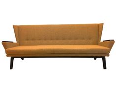 an orange couch sitting on top of a wooden frame