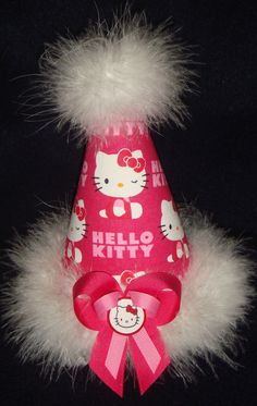 a pink hello kitty party hat with white fur