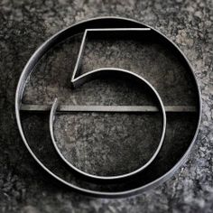 the number five logo is displayed on a granite surface in black and grey tones,