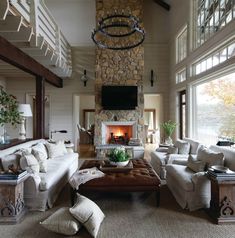 a living room filled with furniture and a fire place in the middle of a room