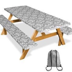 an image of a table and bench set up with the back pack in front of it