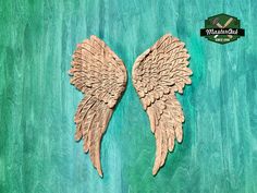 two wooden angel wings on a green background