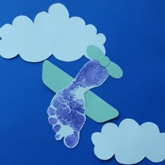 paper clouds and handprints on a blue surface