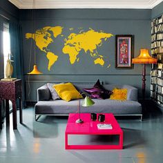 a living room filled with furniture and walls painted in different shades of yellow, grey, and pink